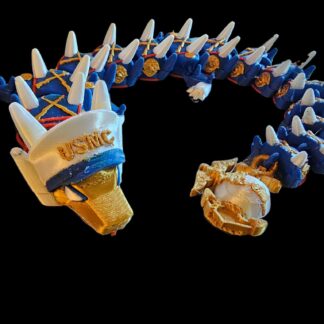 An articulated dragon figurine in blue and gold, wearing a white sailor cap with "USMC" printed on it, on a black background.